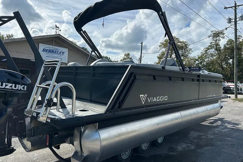 Slide: The Image of 2025 Viaggio Lago V-U pontoon boat with Suzuki motor, parked outdoors. - 6