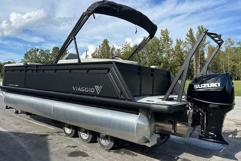 Slide: The Image of 2025 Viaggio Lago V-U pontoon boat with Suzuki outboard motor, parked outdoors. - 8