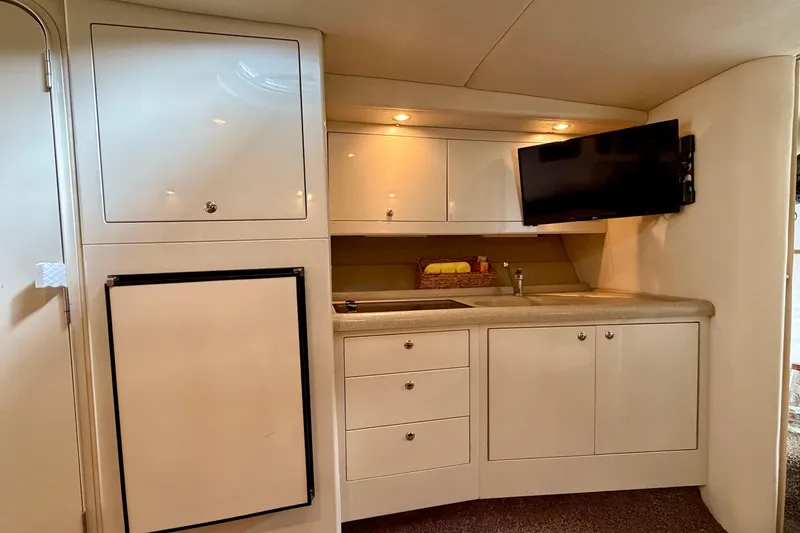 Slide: The Image of Interior of 1999 Wellcraft 45 Excalibur yacht with kitchenette and TV. - 29