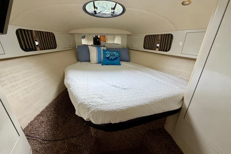 Slide: The Image of 1999 Wellcraft 45 Excalibur cabin interior with bed, TV, and storage cabinets. - 33