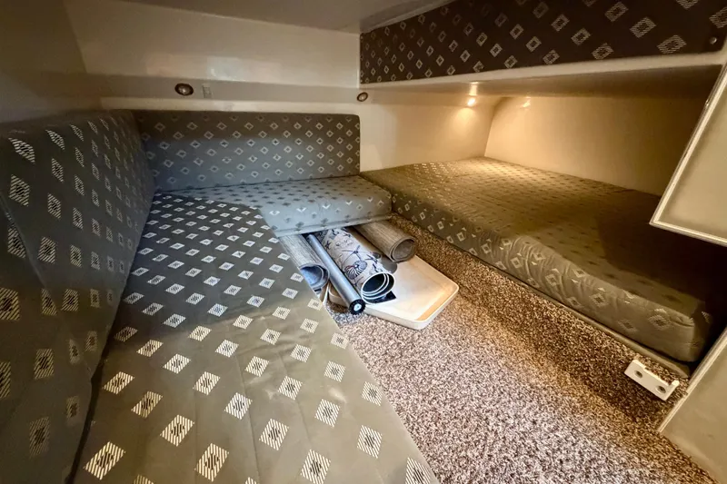 Slide: The Image of 1999 Wellcraft 45 Excalibur cabin interior with patterned bedding and cozy lighting. - 38