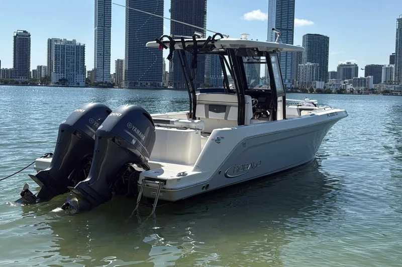 Slide: The Image of 2019 Robalo R272 Center Console boat with twin Yamaha engines on urban waterfront. - 0