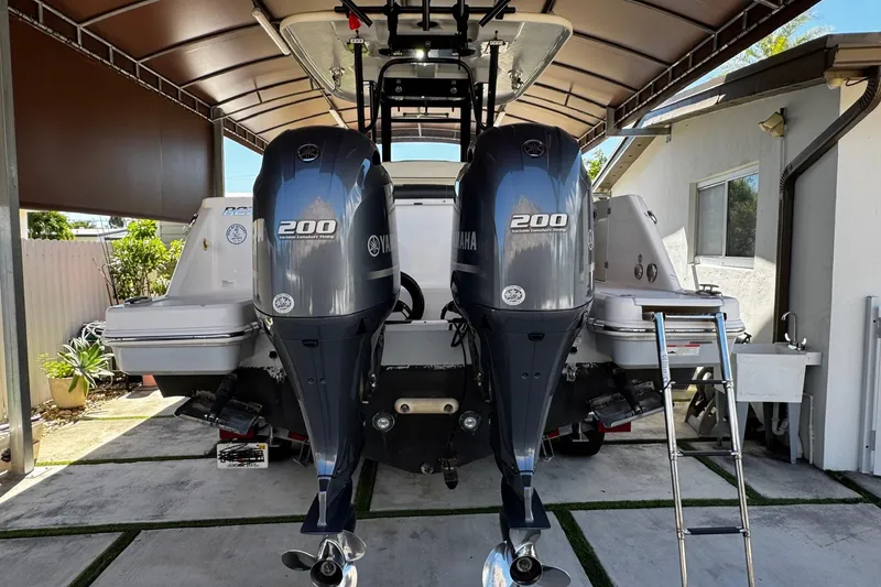 Slide: The Image of 2019 Robalo R272 Center Console with twin Yamaha 200 engines in a covered dock. - 13