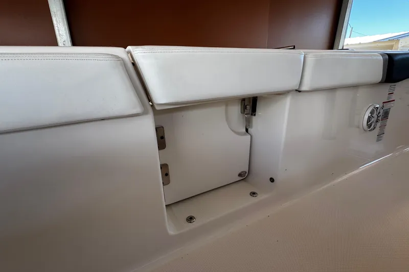 Slide: The Image of 2019 Robalo R272 Center Console boat interior with white cushioned seating. - 28