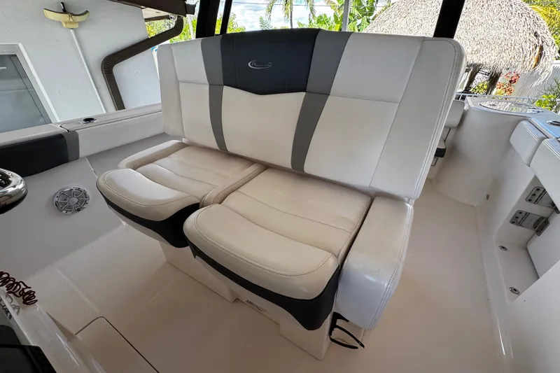 Slide: The Image of 2019 Robalo R272 Center Console boat seating, featuring white and gray cushioned seats. - 31