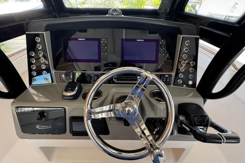 Slide: The Image of 2019 Robalo R272 Center Console dashboard with dual Simrad displays and steering wheel. - 33