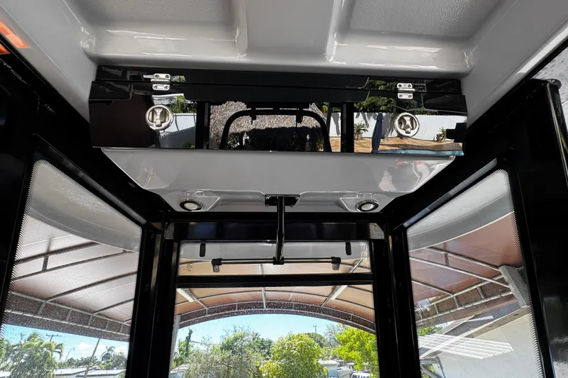 Slide: The Image of 2019 Robalo R272 Center Console interior view with overhead storage and windows. - 40