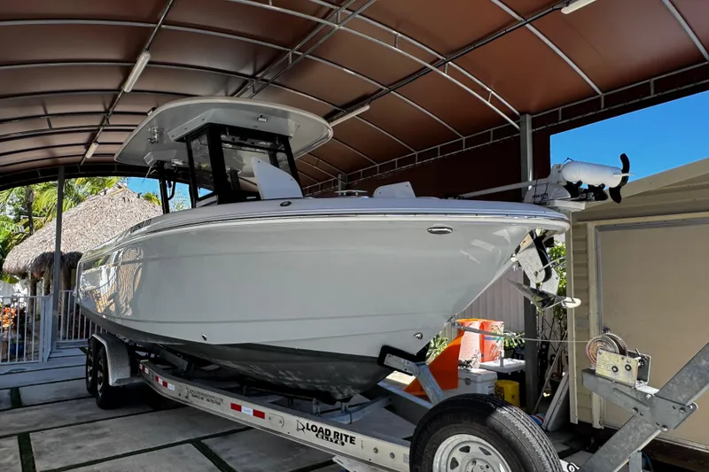 Slide: The Image of 2019 Robalo R272 Center Console boat on trailer under canopy. - 5