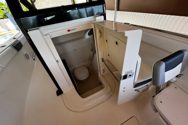 Slide: The Image of 2019 Robalo R272 Center Console boat interior with compact marine toilet. - 50