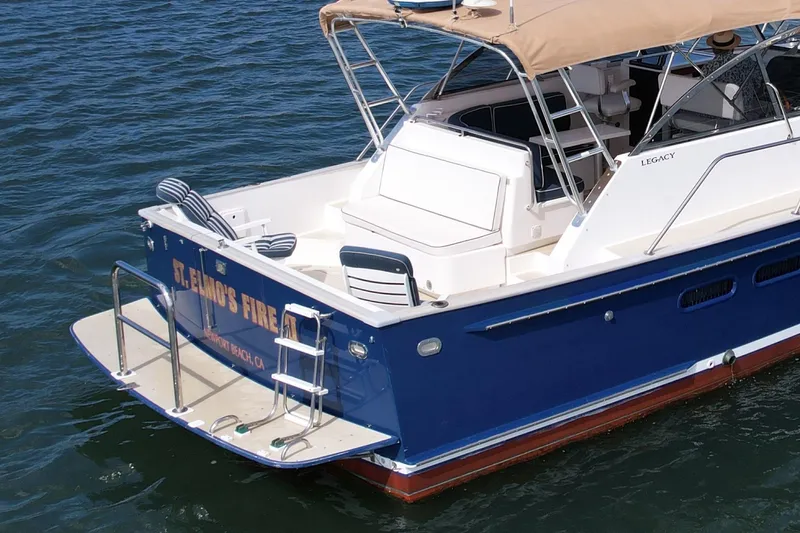 Slide: The Image of 1999 Legacy 40 boat with blue hull and tan canopy on water. - 10