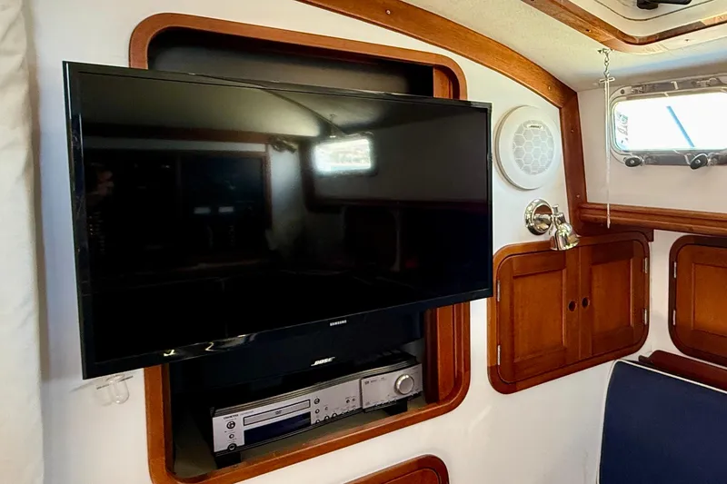 Slide: The Image of Entertainment setup in a 1999 Legacy 40 yacht interior with TV and audio system. - 18