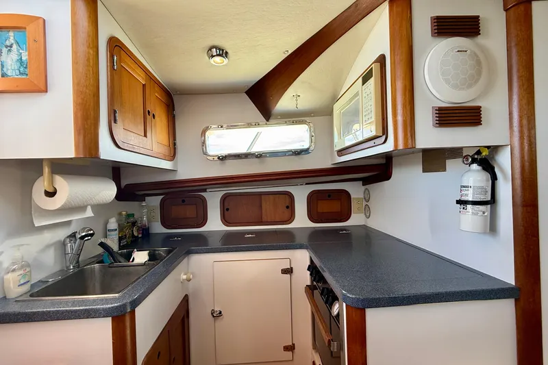 Slide: The Image of Cozy 1999 Legacy 40 boat kitchen with wooden cabinets and modern amenities. - 19