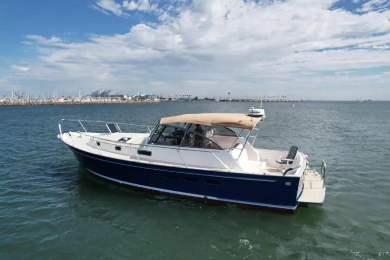 Slide: The Image of 1999 Legacy 40 boat cruising on calm waters under a partly cloudy sky. - 2