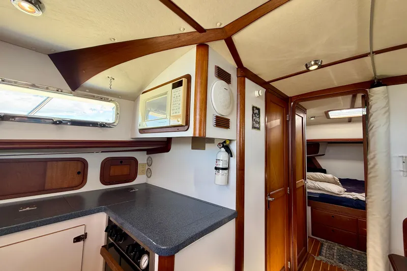 Slide: The Image of Interior of 1999 Legacy 40 yacht featuring kitchen and cozy cabin area. - 20