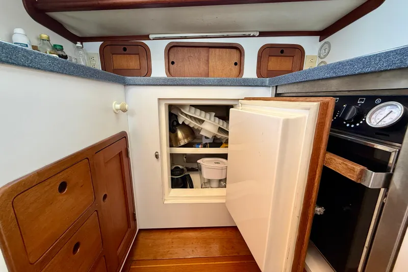 Slide: The Image of 1999 Legacy 40 yacht kitchen with open cabinet, wooden drawers, and countertop appliances. - 22