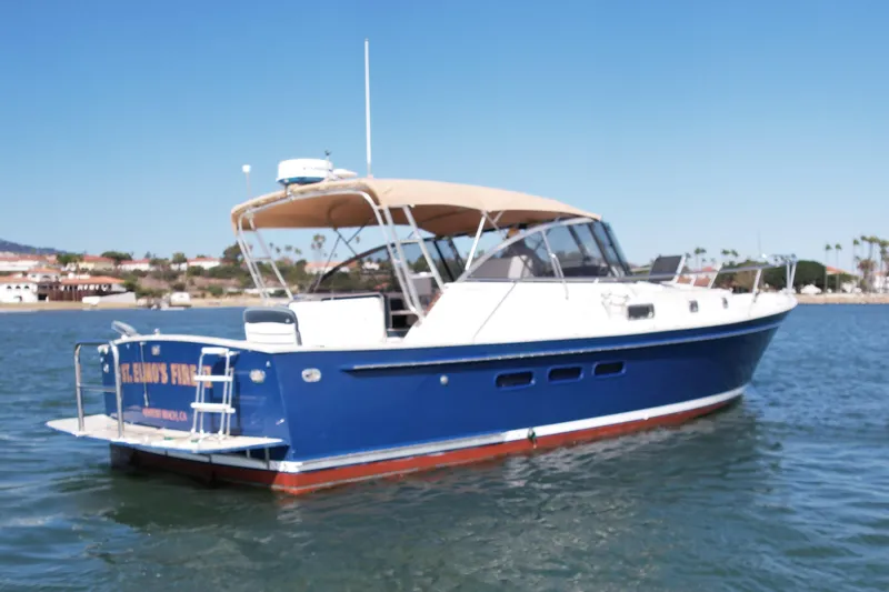 Slide: The Image of Legacy 40 boat from 1999 on calm water, featuring a blue hull and tan canopy. - 3