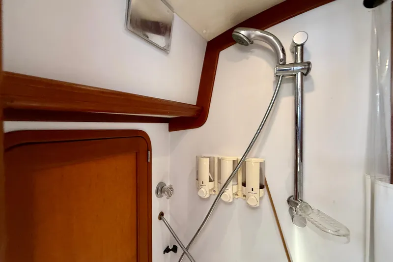 Slide: The Image of Shower area in 1999 Legacy 40 boat with wooden accents and soap dispensers. - 35