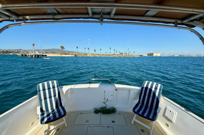 Slide: The Image of Boat deck view with striped chairs, overlooking calm blue water and distant shoreline. Legacy 40, 1999. - 39