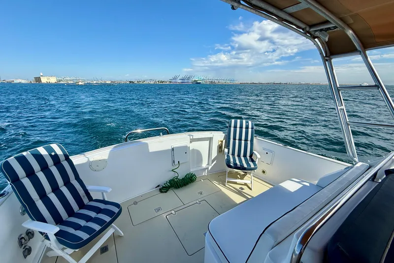 Slide: The Image of Deck view of 1999 Legacy 40 boat with striped chairs on open water. - 45