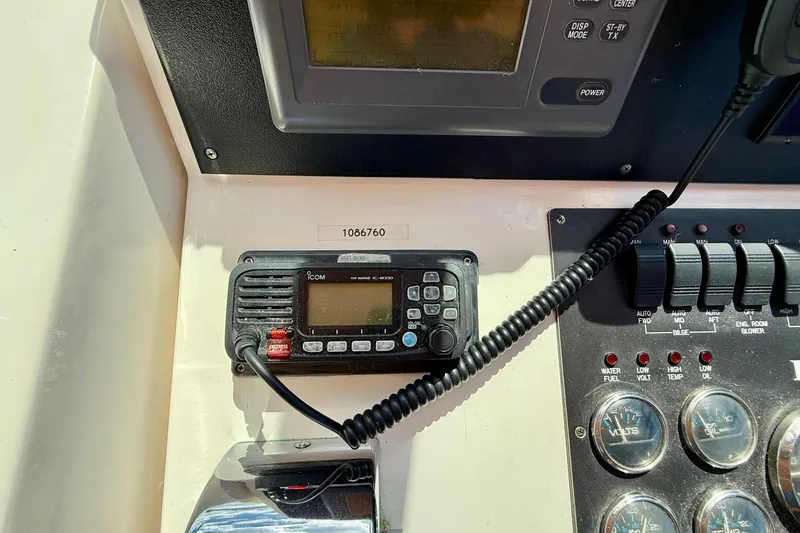 Slide: The Image of Control panel of a 1999 Legacy 40 boat with radio and gauges. - 54