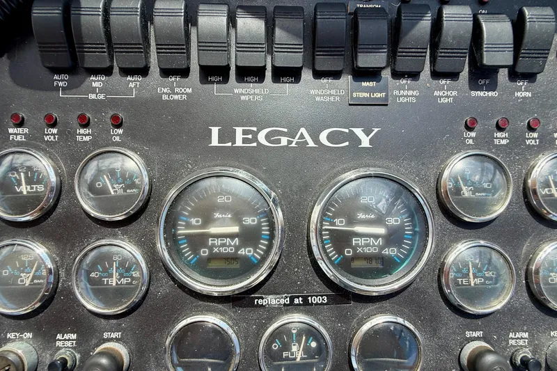 Slide: The Image of Control panel of a 1999 Legacy 40 boat with gauges and switches. - 58