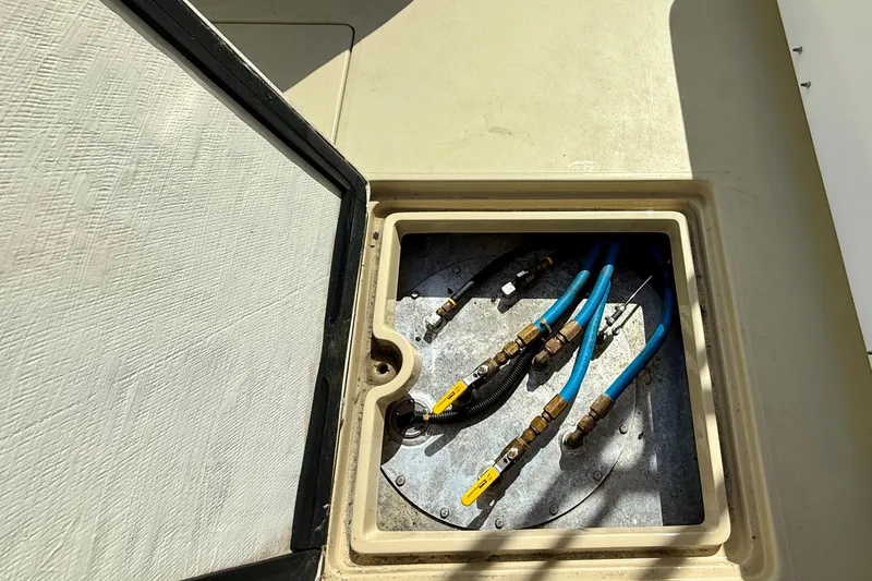 Slide: The Image of Open hatch with blue hoses and valves on a 1999 Legacy 40 boat. - 61