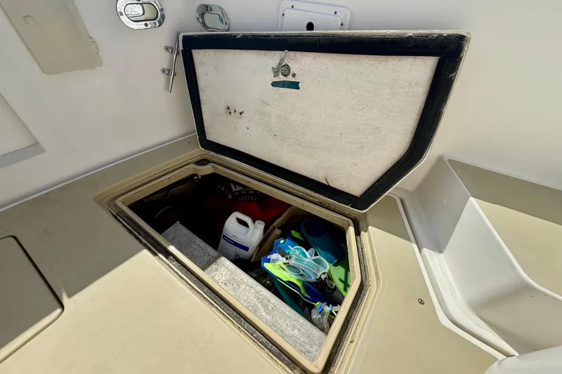 Slide: The Image of Open storage compartment on 1999 Legacy 40 boat, containing various supplies and equipment. - 63