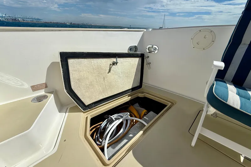 Slide: The Image of Open storage compartment on 1999 Legacy 40 boat deck with coiled cables inside. - 66