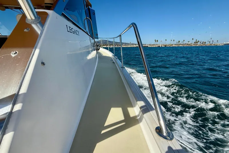 Slide: The Image of 1999 Legacy 40 boat cruising on blue ocean near coastline. - 69