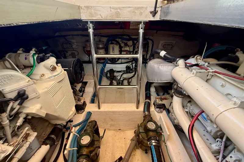 Slide: The Image of Engine room of a 1999 Legacy 40 boat, featuring mechanical components and piping. - 83