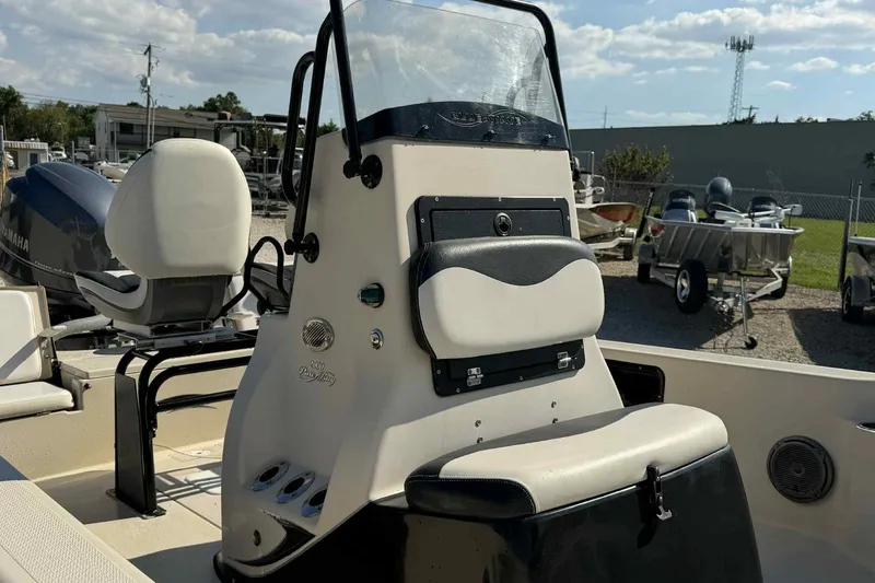 Slide: The Image of 2014 Blue Wave 2000 PureBay boat interior with console and seating, parked outdoors. - 2