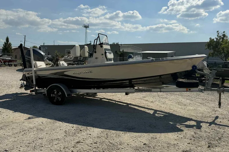 Slide: The Image of 2014 Blue Wave 2000 PureBay boat on trailer under a sunny sky. - 5