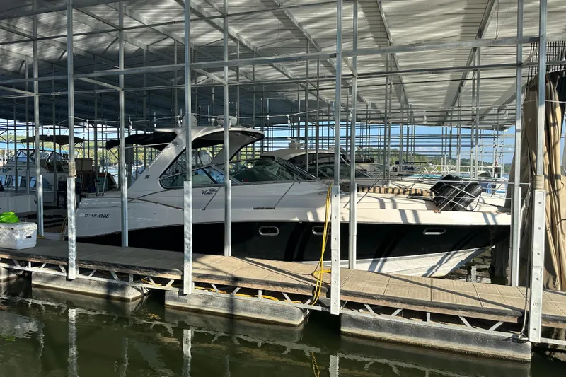 The Image of 2006 Four Winns 378 Vista boat on a serene lake with wooded shoreline. - 0