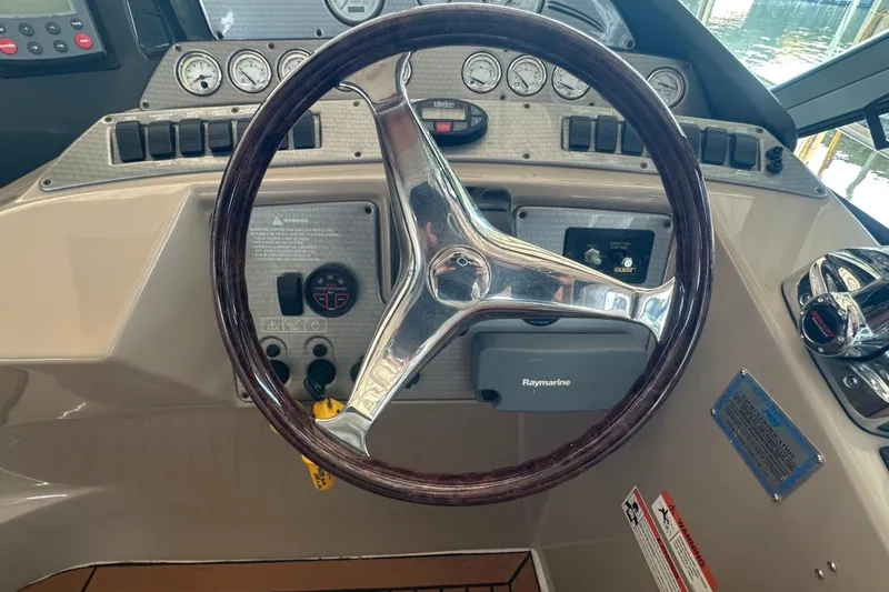 Slide: The Image of 2006 Four Winns 378 Vista yacht docked, featuring a spacious sun deck with striped cushions. - 20