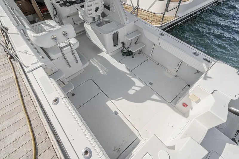 Slide: The Image of 2007 Glacier Bay 2680 Coastal Runner boat interior with seating and storage, docked by water. - 16