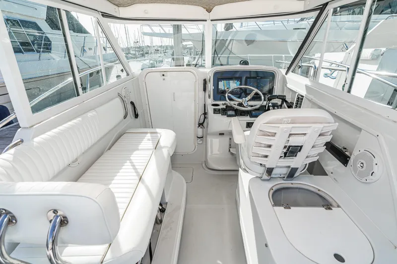 Slide: The Image of 2007 Glacier Bay 2680 Coastal Runner boat interior with white seating and navigation controls. - 23