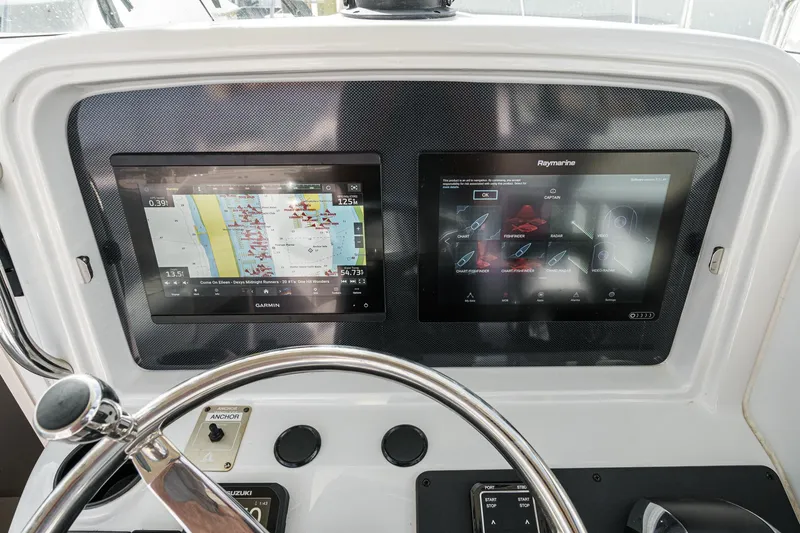 Slide: The Image of 2007 Glacier Bay 2680 Coastal Runner dashboard with dual navigation screens and steering wheel. - 27
