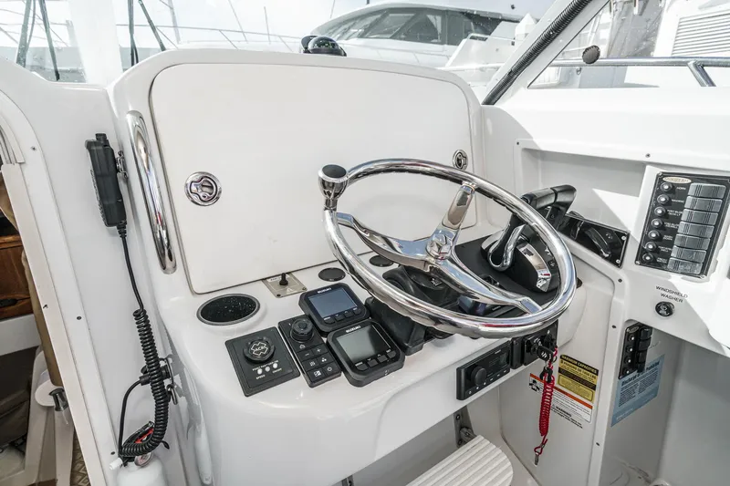 Slide: The Image of 2007 Glacier Bay 2680 Coastal Runner helm with steering wheel and navigation controls. - 34