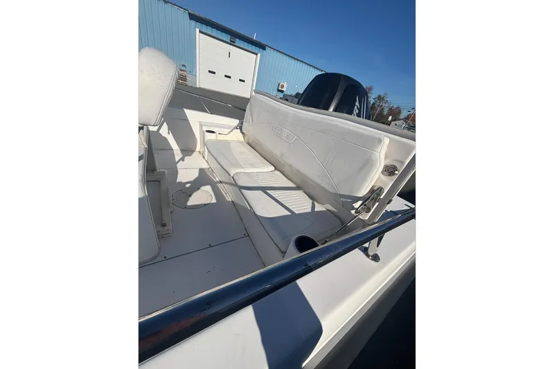 Slide: The Image of 2008 Boston Whaler 180 Dauntless boat interior with seating and storage, docked outdoors. - 4
