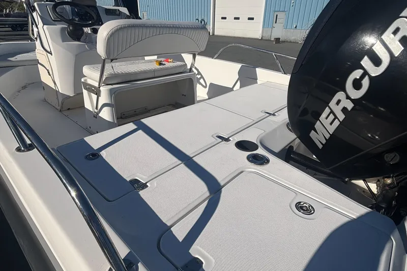 Slide: The Image of 2008 Boston Whaler 180 Dauntless boat interior with Mercury engine, white seating, and storage compartments. - 5