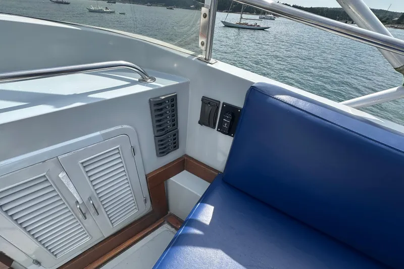 Slide: The Image of 1987 Albin North Sea Trawler interior with blue seating and control panel, overlooking calm waters. - 21