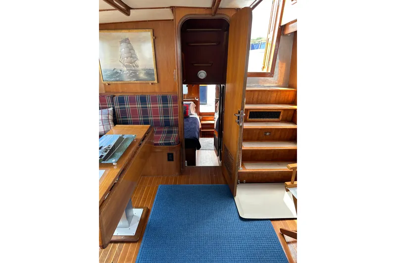 Slide: The Image of 1987 Albin North Sea Trawler interior with wood paneling, plaid seating, and nautical decor. - 55