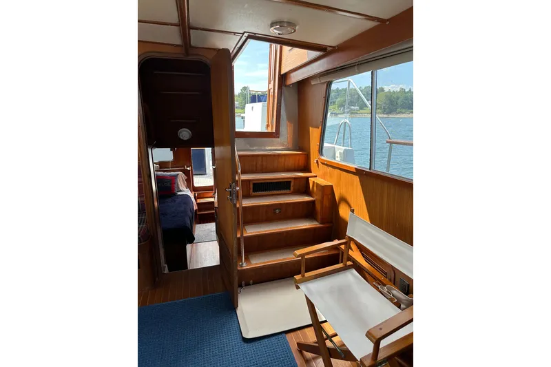 Slide: The Image of Interior of 1987 Albin North Sea Trawler with wooden stairs and seating, overlooking water. - 56