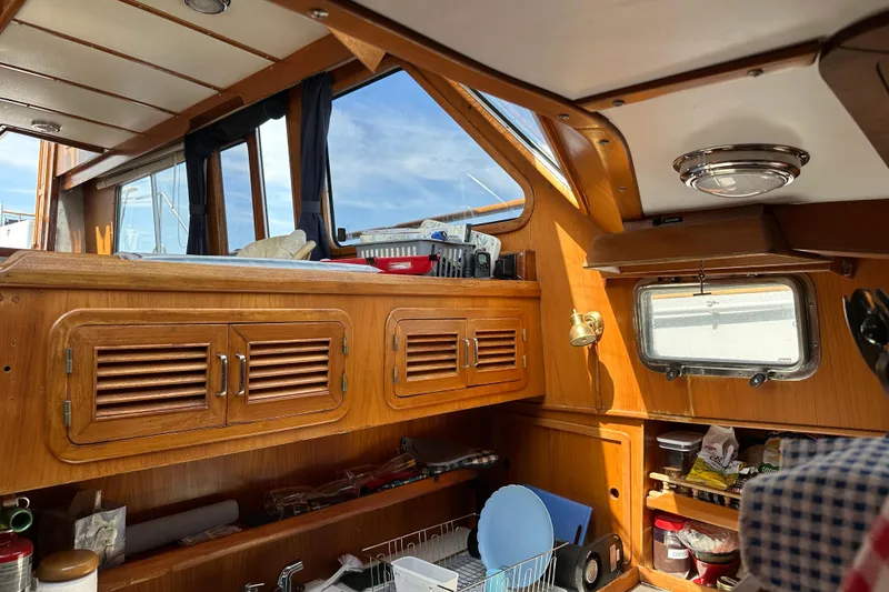 Slide: The Image of Interior of 1987 Albin North Sea Trawler with wooden cabinets and nautical decor. - 67