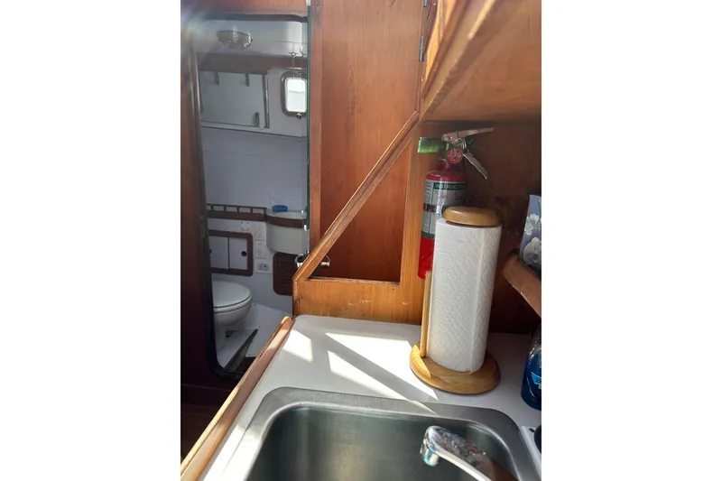 Slide: The Image of 1987 Albin North Sea Trawler interior with sink, paper towel holder, and visible bathroom. - 72