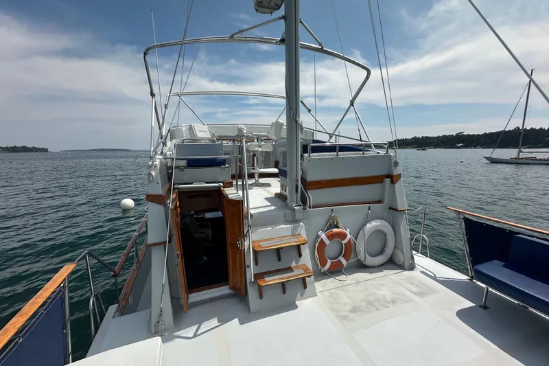 Slide: The Image of 1987 Albin North Sea Trawler on calm waters, featuring open deck and safety equipment. - 16