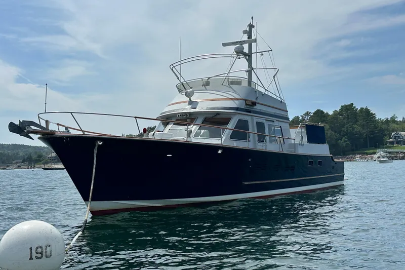 Slide: The Image of 1987 Albin North Sea Trawler anchored in scenic waters, surrounded by lush greenery. - 2