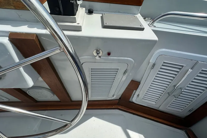 Slide: The Image of Helm area of 1987 Albin North Sea Trawler with steering wheel and control panel. - 22