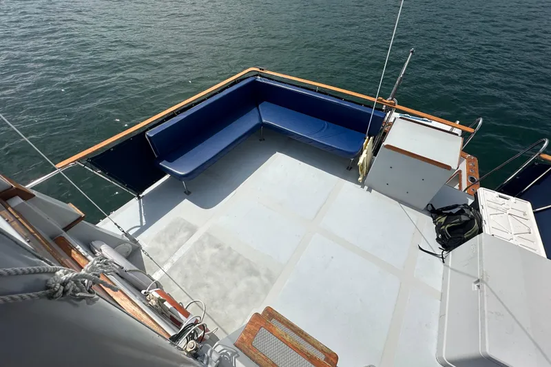 Slide: The Image of 1987 Albin North Sea Trawler deck with blue seating, overlooking calm water. - 25