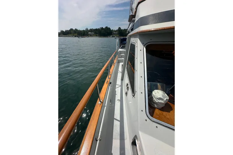Slide: The Image of 1987 Albin North Sea Trawler deck view with wooden railings on calm water. - 31